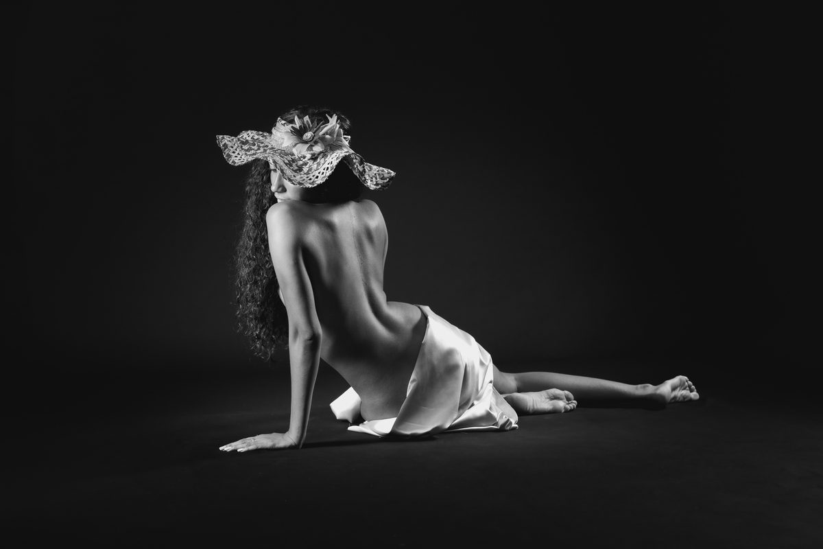 Dos au présent, face aux mémoires. La posture détourne le regard du monde immédiat pour laisser affleurer une beauté silencieuse, héritée et contemplative. — Fabrice Charleux